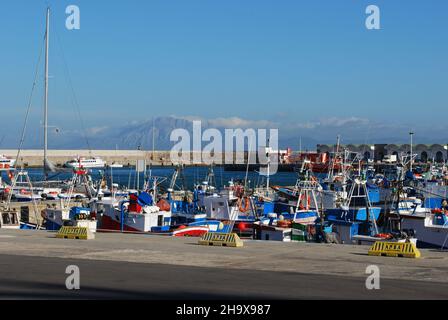 Blick auf die Boote im Hafen mit Blick auf die marokkanische Küste und Berge, Tarifa, Provinz Cadiz, Andalusien, Spanien. Stockfoto