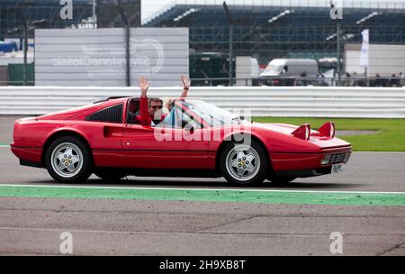Die Besitzer eines Red 1989, Ferrari 328 GTS, winkten der Menge während der Jubiläumsparade des Ferrari Owners Club, bei der Silverstone-Klasse 2017 zu Stockfoto