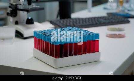 Nahaufnahme von Staubsaugern mit flüssigem Blut im Labor auf dem Schreibtisch. Tablett mit Forschungsflaschen für flüssige dna zur Vorbereitung der wissenschaftlichen Analyse. Ausrüstung für die pharmazeutische Entwicklungsindustrie Stockfoto
