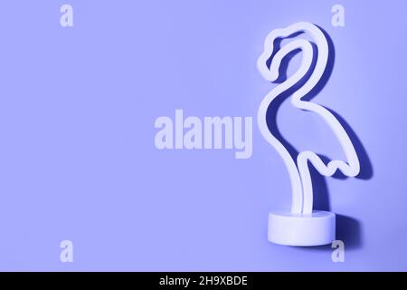 Neon Flamingo LED-Lampe isoliert auf violettem Hintergrund. Modernes Nachtlicht für Kinder. Stockfoto