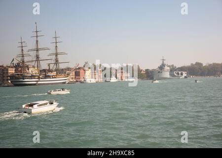 Es gibt Schiffe in der Nähe der Pier, die größte - ein altes Segelschiff und ein neues Flugzeug-tragende Kreuzer. Es gibt verschiedene kleine Boote in ihrer Nähe Stockfoto