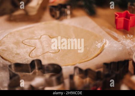 Lebkuchen zu Hause machen. Schneiden von Keksen aus Lebkuchenteig Stockfoto