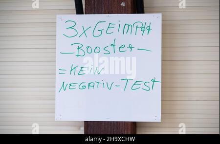 Hannover, Deutschland. 09th Dez 2021. Auf dem Weihnachtsmarkt hängt ein Schild mit der Aufschrift '3x geimpfter Booster = kein negativer Test'. Aufgrund der Corona-Pandemie gilt die 2G-plus-Regel auf dem Weihnachtsmarkt: Nur geimpfte und wiedergeborene Personen mit aktuellen negativen Corona-Tests dürfen Lebensmittel und Getränke kaufen. Diejenigen, die bereits dreimal geimpft wurden, müssen jedoch keinen Test mehr vorlegen. Quelle: Julian Stratenschulte/dpa/Alamy Live News Stockfoto