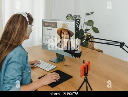 Weibliche Influencerin, die im Aufnahmestudio einen Computer benutzt Stockfoto