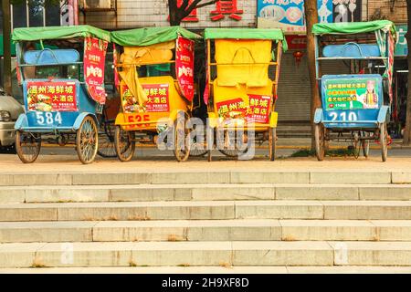 Vier Rikschas parkten auf einer Straße in Jiashan, China Stockfoto