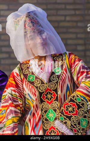 BUCHARA, USBEKISTAN - 30. APRIL 2018: Junge Tänzerin in traditioneller Kleidung im Zentrum von Buchara, Usbekistan Stockfoto