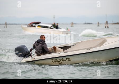 Venedig, Italien - 27. Oktober 2021: Kleines Transportboot in der Lagune von Venedig (Italien) an einem bewölkten Tag im Winter Stockfoto