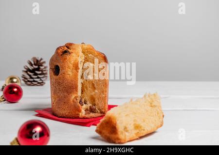 Italienische Dessert Mini-Panettone von Weihnachtsdekorationen auf weißem Hintergrund mit Kopierraum umgeben. Weihnachten oder Neujahr Gebäck Food Konzept Stockfoto