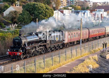 Chalkwell, Southend on Sea, Essex, Großbritannien. 9th Dez 2021. Ein Dampfzug hat Southend on Sea verlassen, um nach Oxford zu ihrem Weihnachtsmarkt und ihrem Weihnachtslieddienst zu fahren, der an der Themse in Chalkwell vorbeifährt. Der von Steam Dreams organisierte Sonderzug wird von der ehemaligen British Rail LMS Stanier Black Five Dampflokomotive Nr. 44871, die 1945 gebaut wurde und eine der letzten war, die vor dem Abtransport von Dampf aus den britischen Eisenbahnen im Jahr 1968 Personenverkehr Betrieb, transportiert. 44871 ist eine von wenigen Dampflokomotiven, die für Sonderfahrten auf Hauptstrecken freigegeben sind Stockfoto