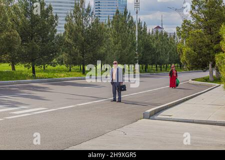 ASCHGABAT, TURKMENISTAN - 17. APRIL 2018: Menschen vor Ort an einer Bushaltestelle in Aschgabat, Turkmenistan Stockfoto