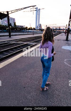 BUKAREST, RUMÄNIEN - 08. Dez 2021: Junges Mädchen, das alleine auf dem Bahnsteig läuft und Fotos auf dem Bahnhof macht Stockfoto