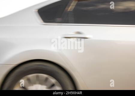 Bewegungsunschärfe-Bild eines modernen Luxuswagens, der schnell fährt. Stockfoto