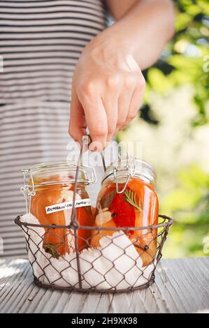 Eingelegte Paprika mit Chili, Rosmarin, Knoblauch und schwarzem Pfeffer in Gläsern Stockfoto