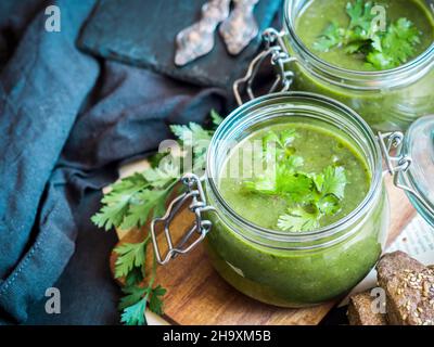 Vegane Creme aus gebackenen Zucchini, Süßkartoffeln und Spinatsuppe, serviert in Einmachgläsern Stockfoto