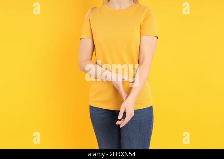 Frau in leerem orangefarbenem T-Shirt auf gelbem Hintergrund Stockfoto