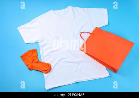 Leeres T-Shirt, Tasche und Socken auf blauem Hintergrund Stockfoto