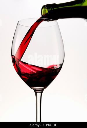 Rotwein wird in ein Glas gegossen Stockfoto