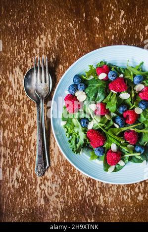 Grüner Salat mit Rucola, Beeren und Mandeln Stockfoto