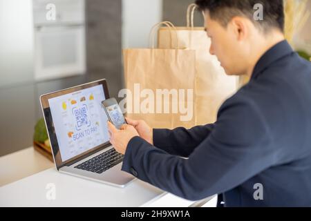 Mann mit Smartphone für die Zahlung im Online-Shop Stockfoto