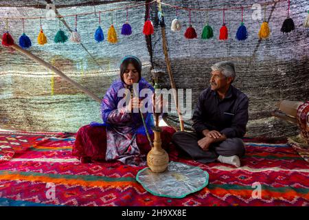 Shiraz, Iran - 11. Mai 2018: Qashqai nomadische Familie raucht Shisha. Qasqhai sind nomadische Menschen, die in temporären Dörfern leben. Stockfoto