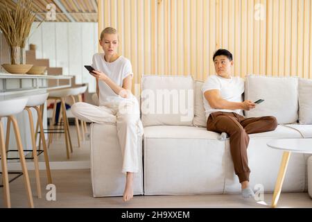 Paar mit Smartphones auf dem Sofa zu Hause Stockfoto
