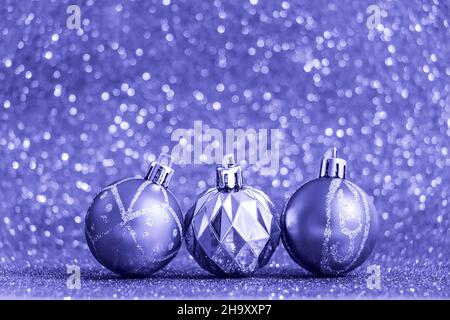Weihnachtskugeln auf glänzendem violettem Hintergrund. Trendige Farbe des Jahres 2022. Neujahrskonzept für die Urlaubskarte. Für Text platzieren. Stockfoto