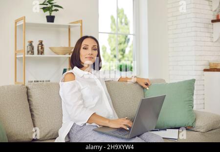 Porträt einer selbstbewussten und stilvollen reifen Geschäftsfrau, die von zu Hause aus aus aus arbeitet. Stockfoto