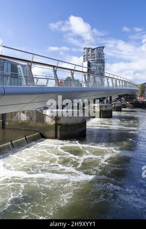 BELFAST, VEREINIGTES KÖNIGREICH - 04. Okt 2021: Eine vertikale Aufnahme der berühmten Fußgängerbrücke Lagan Weir in Belfast unter einem blau bewölkten Himmel Stockfoto