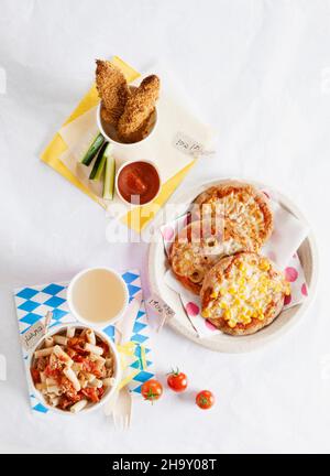 Verschiedene Kindergerichte: Mini-Pizzas, Pasta mit Tomaten und Chicken Nuggets Stockfoto