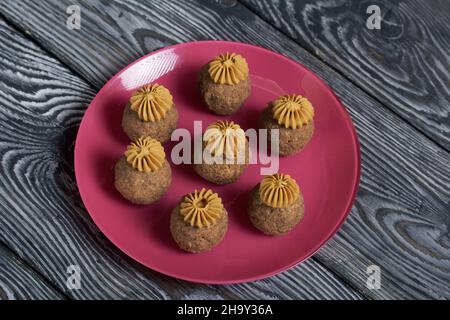 Bananenkuchen mit Buttercreme. Auf einen Teller legen. Auf schwarzen Kiefernbrettern. Nahaufnahme. Stockfoto