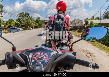 BOHOL ISLAND, PHILIPPINEN - 11. FEBRUAR 2018: Motorradfahren auf einer Straße auf der Insel Bohol. Stockfoto