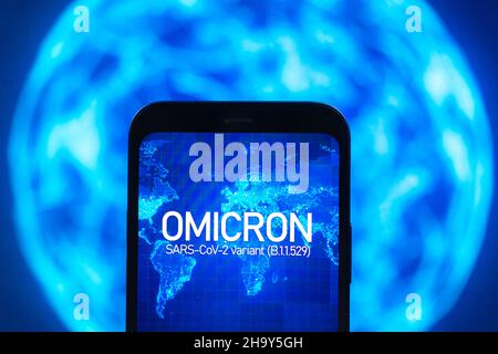 Omicron-Variante des Coronavirus. Mobiltelefon mit omicron-Text auf der globalen Karte des Planeten Erde. SARS-CoV-2, B.1.1.529. Weltepidemien-Conce Stockfoto