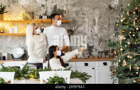 Menschen mit Geschenken, die Gesichtsmasken während des Coronavirus- und Grippeausbruchs an Weihnachten tragen. Schutz vor Viren und Krankheiten, Quarantäne zu Hause. COVID-2019. Stockfoto