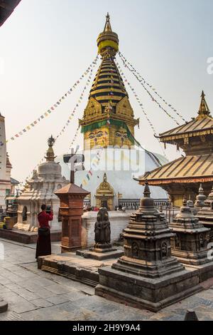 Ein buddhistischer Mönch fotografiert mit seiner Tafel im Swayambhunath-Tempelkomplex in Kathmandu, Nepal. Stockfoto