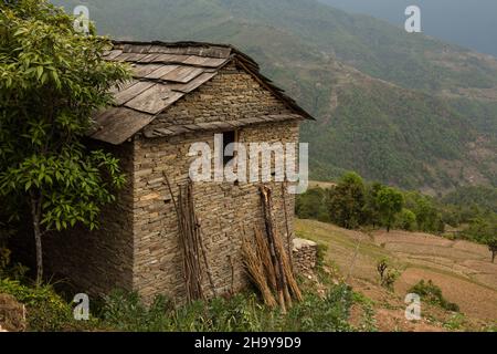 Ein traditionelles nepalesisches Bauernhaus aus Stein mit einem Schiefer-Ziegeldach im Himalaya-Vorgebirgsdorf Dhampus, Nepal. Stockfoto