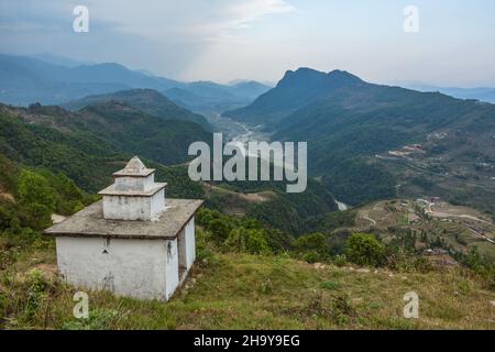 Eine Stupa in der Nähe des Himalaya-Vorgebirgsdorfes Dhampus mit Blick auf das Seti Gendaki River Valley und den Sarangkot-Hügel in der Nähe von Pokhara, Nepal. Stockfoto