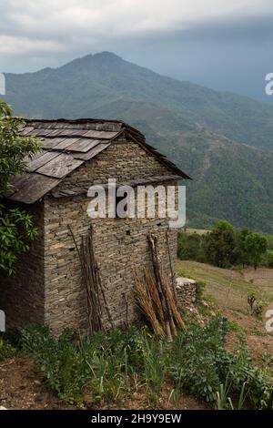 Ein traditionelles nepalesisches Bauernhaus aus Stein mit einem Schiefer-Ziegeldach im Himalaya-Vorgebirgsdorf Dhampus, Nepal. Stockfoto