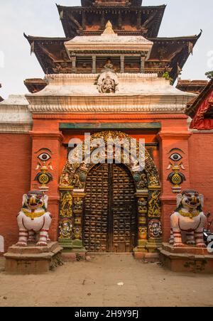 Der Taleju-Tempel erhebt sich hinter den weißen Löwen, die das verzierte Singha Dhoka-Tor bewachen. Durbar Square, Kathamandu, Nepal. Stockfoto