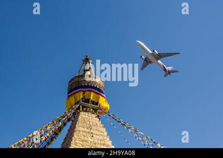 Ein Passagierjet der Boeing 777-200 von Thai Airways fliegt über die Boudhanath Stupa in Kathmandu, Nepal. Stockfoto