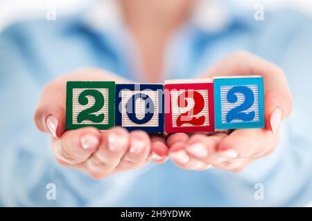 Neues Jahr 2022 Business- und Lifestyle-Konzept. Frau mit Holzwürfeln. Stockfoto