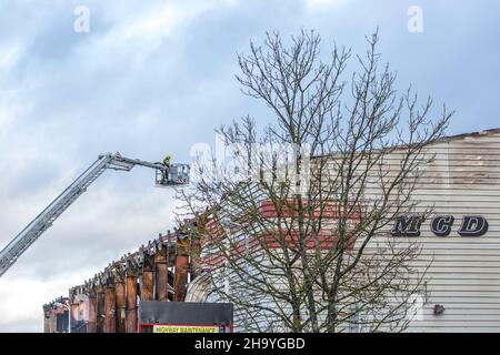 Kidderminster, Großbritannien, 8th. Dezember 2021. Feuerwehrleute und Polizei sind immer noch beim Lagerfeuer auf dem Hoo Farm Industrial Estate, Kidderminster. Die Überreste des Gebäudes von MCD werden noch 48 Stunden nach Beginn des Feuers mit Wasser übergossen. Rauch und kleine Brände sind immer noch offensichtlich, da die Feuerwehr nun die Kontrolle über die Situation hat. Kredit: Lee Hudson Stockfoto