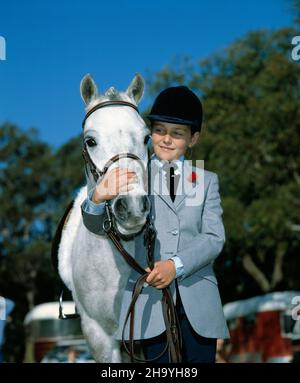 Kinder. Junges Mädchen im Freien posiert mit ihrem Pony bei gymkhana. Stockfoto