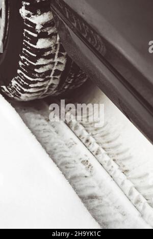 Auto-Reifen-Spuren im Schnee Stockfoto