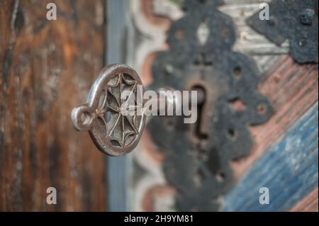 Nahaufnahme Detailansicht des alten massiven Metallschlüssels in einer großen riesigen Kirche aus Holz, einer alten Tür. Eingang des Geheimnisses. Traditionelle gotische Grunge vintage st Stockfoto