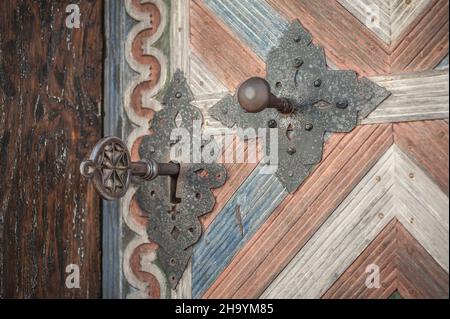 Nahaufnahme Detailansicht des alten massiven Metallschlüssels in einer großen riesigen Kirche aus Holz, einer alten Tür. Eingang des Geheimnisses. Traditionelle gotische Grunge vintage st Stockfoto