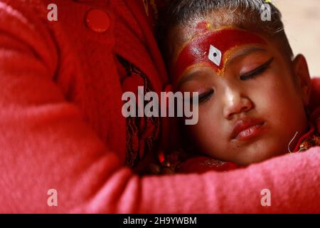 Lalitpur, Bagmati, Nepal. 9th Dez 2021. Die lebende Göttin Kumari von Bungmati schläft auf dem Schoß ihrer Mutter, während sie an dem Reiseereignis von Lord Rato Machindranath, der auch als ''Roter Gott von Lalitpur'' bekannt ist, von seinem Tempel in Bungmati im Kathmandu-Tal nach Macchondra Bahal in Patan teilnimmt. Der Rote Gott bleibt nach alter Tradition 6 Monate in Bungmati und anderen Jahreshälften in Patan. Nepals alte Stadt wie Bungmati, Sankhu, Panauti und andere haben auch die lebende Göttin Kumari, die Reinkarnation der Göttin Taleju Bhawani. Quelle: Amit Machamasi/ZUMA Wire/Alamy Live News Stockfoto