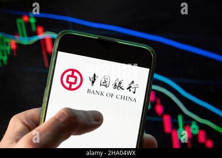 China. 09th Dez 2021. In dieser Abbildung sehen Sie das Logo des chinesischen staatlichen Geschäftsbankunternehmens Bank of China, das auf einem Smartphone mit einem Index der wirtschaftlichen Börse im Hintergrund zu sehen ist. (Foto von Budrul Chukrut/SOPA Images/Sipa USA) Quelle: SIPA USA/Alamy Live News Stockfoto