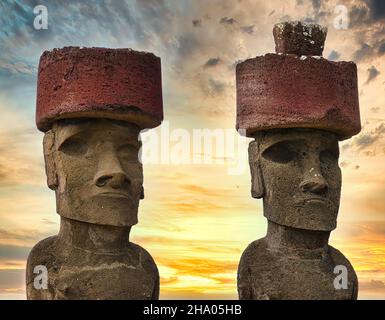 AHU Nao-Nao Moais trägt einen roten Hut, mit einem romantischen und dramatischen Sonnenuntergang Himmel, Rapa Nui Nationalpark, Osterinsel, Chile, UNESCO-Weltkulturerbe Stockfoto