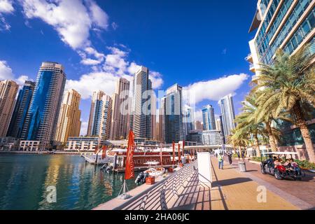 Wunderschöne Aussicht auf die teuren Yachten und Motorboote, die an den Piers der Dubai Marina festgemacht sind, umgeben von hohen Wolkenkratzern, Dubai, VAE Stockfoto