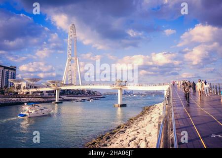 Wunderschöner Blick auf eine Yacht, die an der Ain Dubai, dem größten Riesenrad der Welt, auf der Bluewaters Island im Dubai Marina District, Dubai, VAE, vorbeifährt Stockfoto